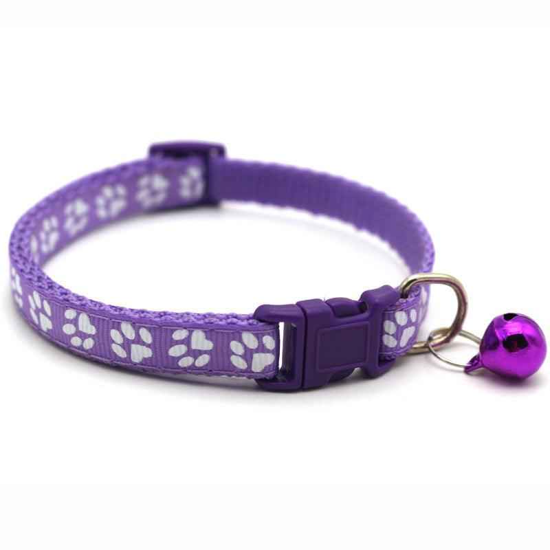 Purple pet bell collar with white paw-print pattern, plastic buckle, and shiny bell
