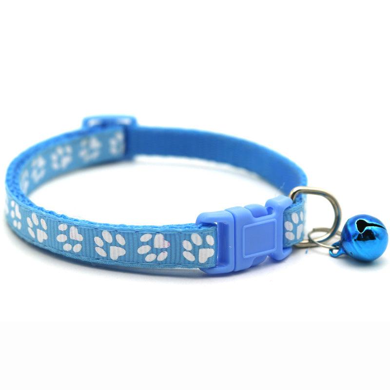 Blue pet bell collar with white paw prints, adjustable buckle, and attached bell