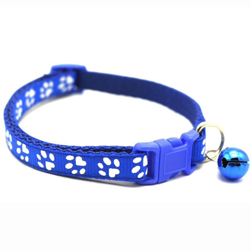 Royal blue pet bell collar with white paw-print pattern, adjustable buckle, and bell