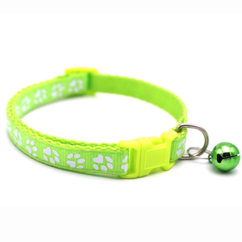 Light green pet bell collar with white paw-print pattern, adjustable buckle, and bell