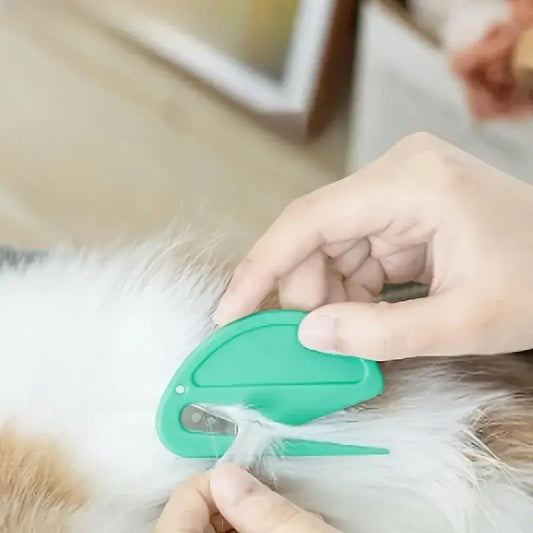 Green knotting grooming comb with blade, held against fluffy dog fur