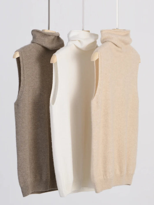 Sleeveless merino wool turtleneck vests in dark brown, white, and light beige on hangers