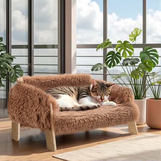 Raised plush cat sofa bed in brown with wooden legs, cat resting on the cushion.