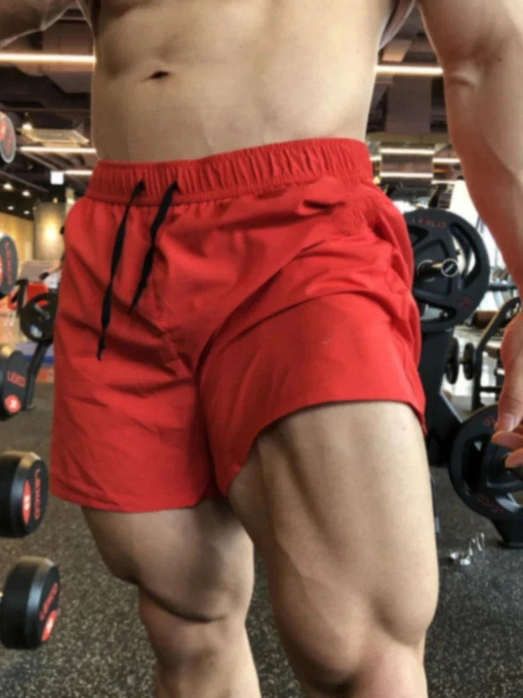 Men's red athletic shorts with elastic waist and drawstring ties