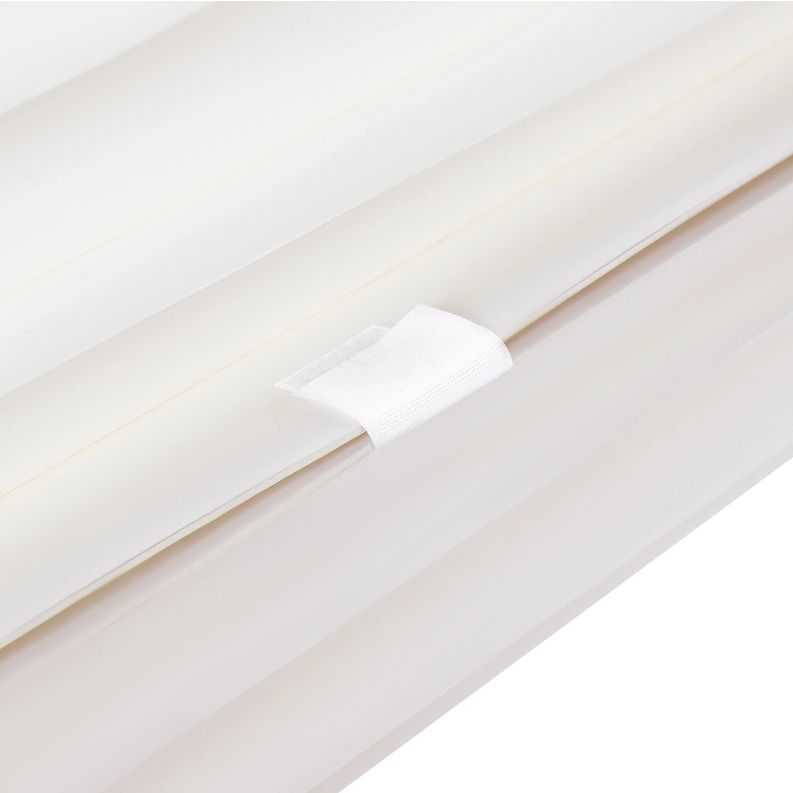 Milky white foldable cardboard strip with a small fabric fastener tab