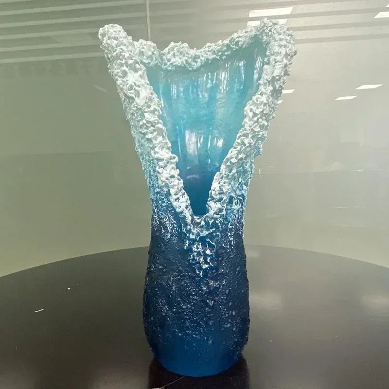 Tall blue resin vase with bright white wave crest and glossy textured surface.