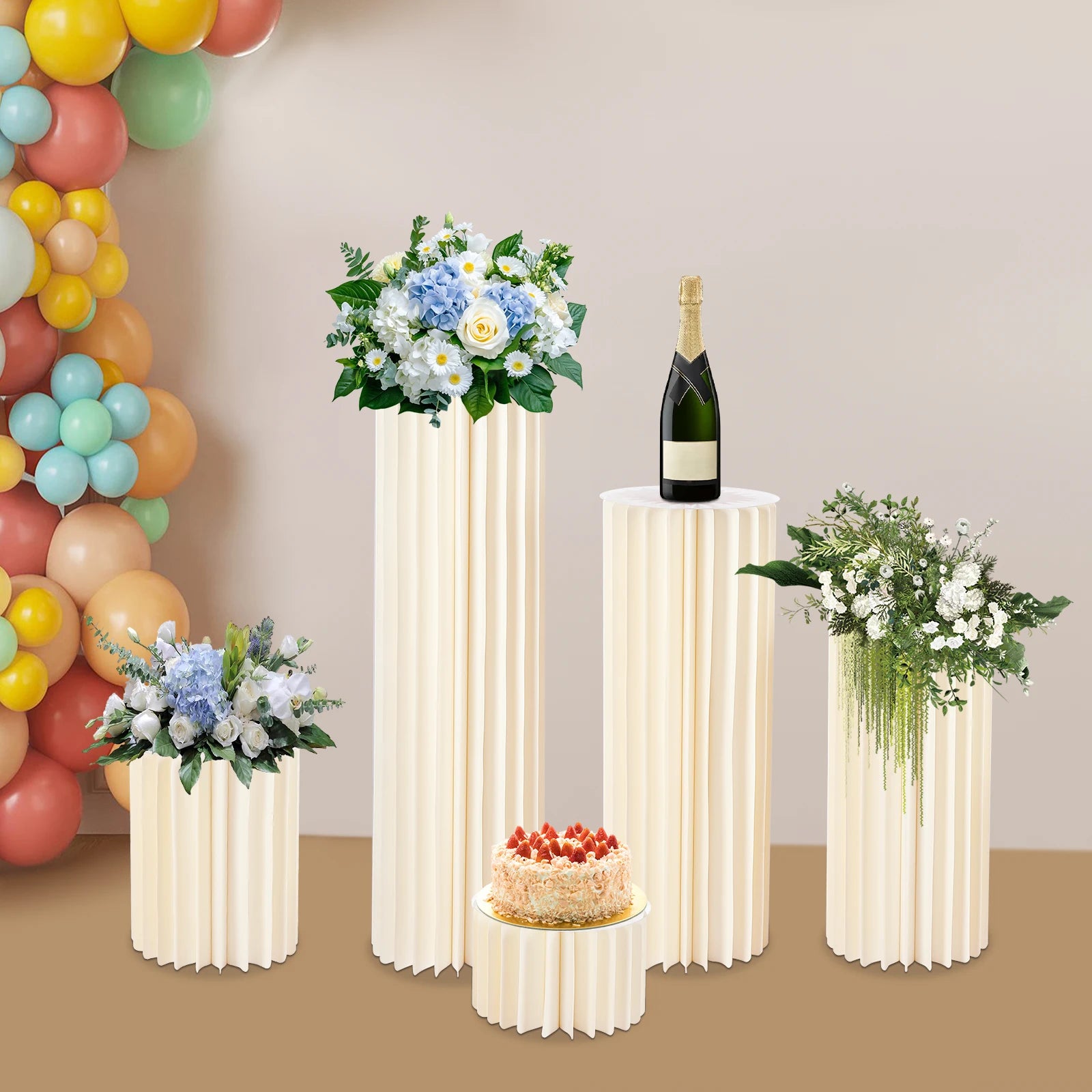 Milky white ribbed cardboard flower stands holding bouquets, cakes, and a bottle display