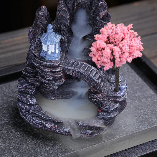 Resin incense burner tower with waterfall smoke and pink flowering tree, dark stone base