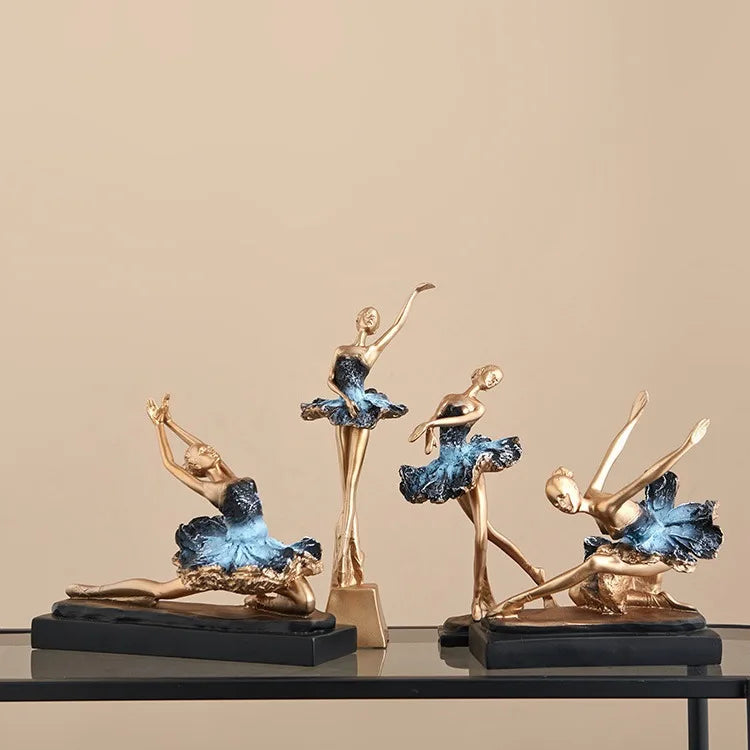 Four blue ballet dancer resin sculptures in gold, with blue tutus on black bases