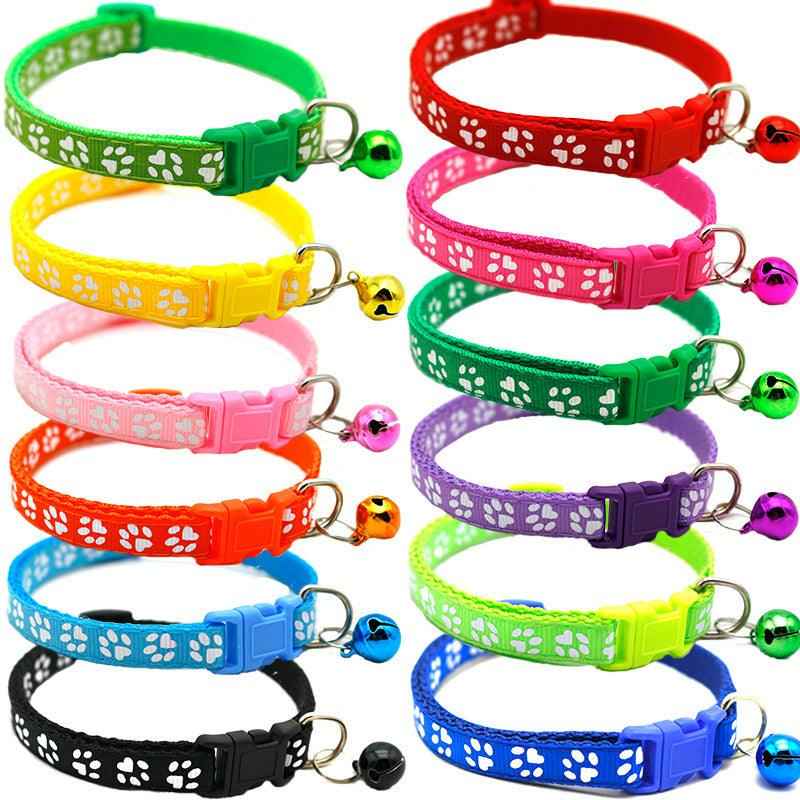 Colorful pet bell collar set with paw-print fabric and dangling bells, multiple shades shown