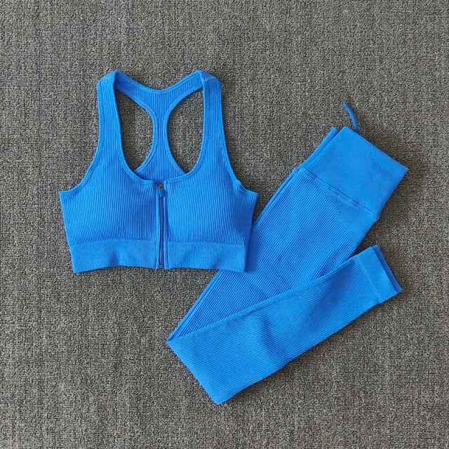 Bright blue seamless yoga set with zip-front sports bra and ribbed leggings, flat lay.
