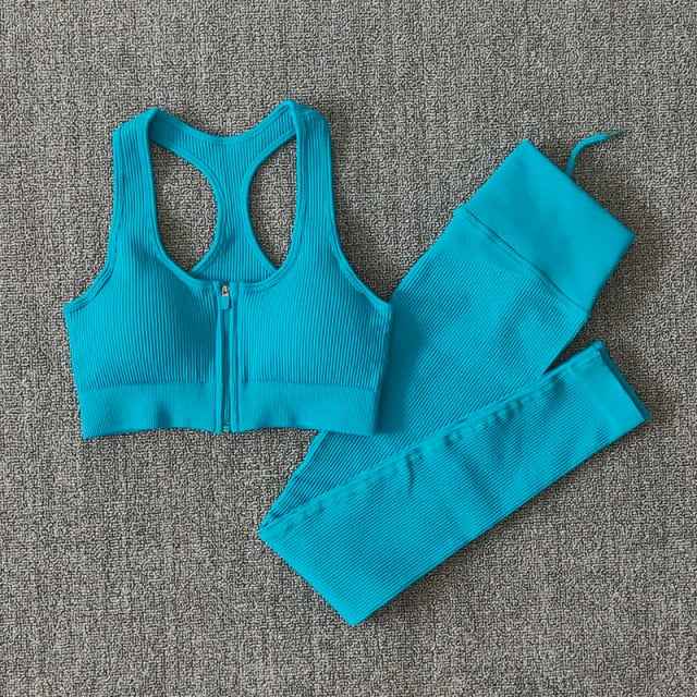 Teal seamless yoga set with zip-front sports bra and ribbed leggings, flat lay.